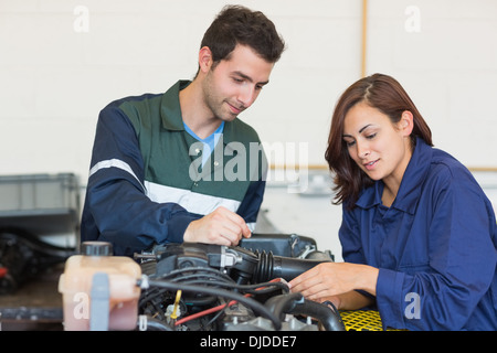 Content instructor and trainee checking a machine Stock Photo