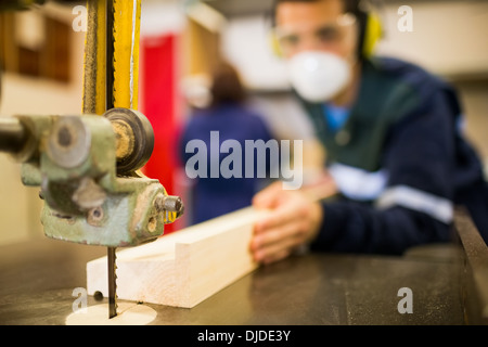 Carpenter wearing safety protection using saw Stock Photo