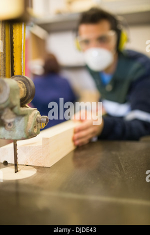 Carpenter wearing safety protection using a saw Stock Photo