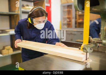 Trainee wearing safety protection using saw Stock Photo