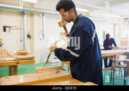 Focused craftsman using mallet and chisel Stock Photo