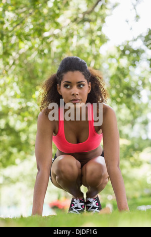 Full length of a toned young woman crouching in park Stock Photo