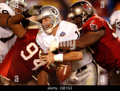 Tampa Bay player Warren Sapp gets grabbed by Raider Lincoln Kennedy as he  pass rushes QB Rich Gannon of Super Bowl XXXVII between the Oakland Raiders  and the Tampa Bay Buccaneers, January