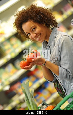 Woman buys vegetable and food in the supermarket Stock Photo