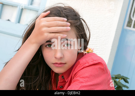 portrait of a girl holding here forehead. Stock Photo