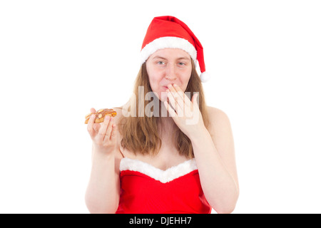 Young Mrs. Claus taken by surprise eating gingerbread Stock Photo