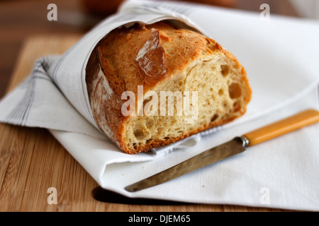 Loaf of cut sourdough with knife Stock Photo