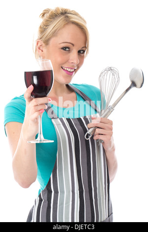 Model Released. Attractive Young Woman Holding Kitchen Utensils Drinking Red Wine Stock Photo