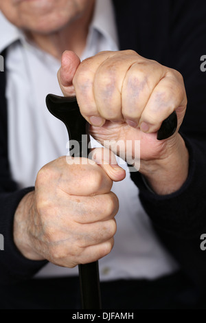 Hands of an old senior adult man holding on a crutch Stock Photo