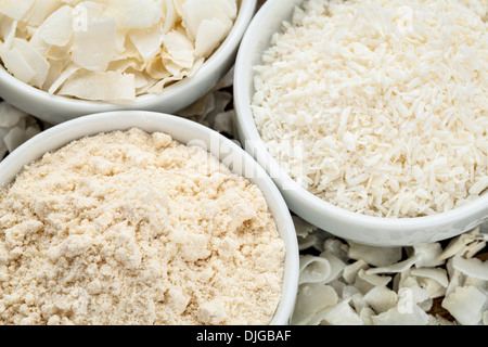 coconut flour and flakes in three white ceramic bowls Stock Photo