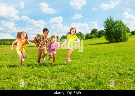 Kids running in the park together 6 and 7 years old, diversity looking, boys and girls running together  Stock Photo