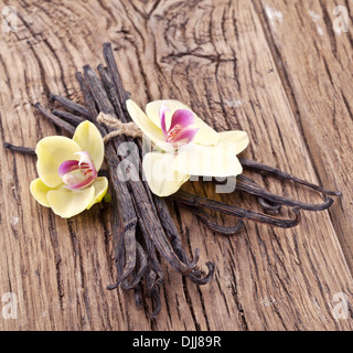 Vanilla sticks with a flower on a wooden table. Stock Photo