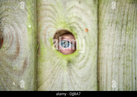 Eye / eyes of a nosey neighbour / neighbor peeping / spying through spy