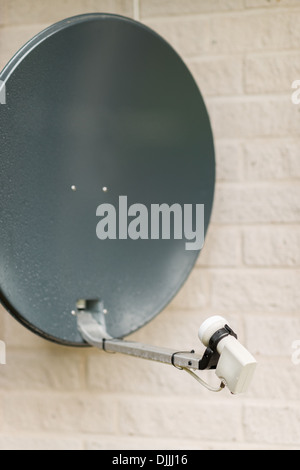 Satellite is attached to the brick wall of the house, close-up Stock Photo