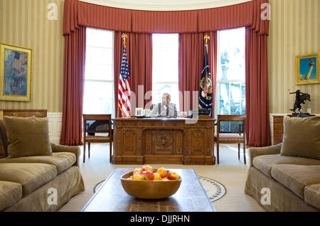 US President Barack Obama makes Thanksgiving Day phone calls to U.S. troops from the Oval Office of the White House November 28, 2013 in Washington, DC. Stock Photo