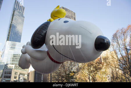 New York, NY, USA. 28th Nov, 2013. Snoopy and Woodstock characters, from the cartoon Peanuts, balloon flying through city buildings on W 59th street during the Macy's 87th Annual Thanksgiving Day Parade on November 28, 2013 in New York City, New York. Credit:  Scott Cornell/Alamy Live News Stock Photo