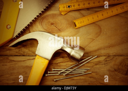Hammer, nails, ruler and saw on wood Stock Photo