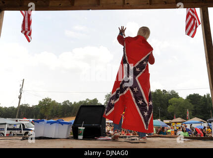 Mar 11, 2008 - East Dublin, Georgia, USA - Ronnie Mullis sports a Confederate Battle flag cape while performing at the 13th annual Summer Redneck Games at Buckeye Park in East Dublin, Georgia, on Saturday. The annual homage to Southerners, began as a spoof to the 1996 Summer Olympics in Atlanta. Thousands of revelers attend the event whose events include bobbing for pigs feet, the  Stock Photo
