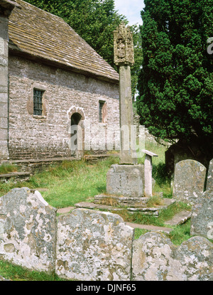 St Issui's Church, Partrishow, Powys: churchyard preaching cross opposite stone benches running alongside the chancel and nave. Stock Photo