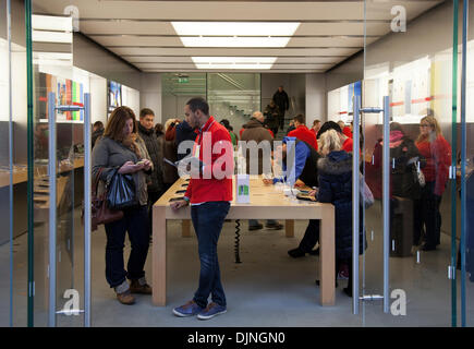 Apple Technology business stores in Liverpool, Merseyside, UK 29th November, 2013. Customers in Apple's store in Liverpool One city centre holiday shopping season, retail shops, stores, Christmas shoppers, discount sale shopping, and consumer spending on Black Friday considered to be the biggest shopping day of the year.   U.K. retailers have embraced the U.S. post-holiday sale bonanza, even though many customers were left surprised by wall-to-wall discounts in their favourite stores as some went bonkers for bargains. Liverpool's business district. Stock Photo