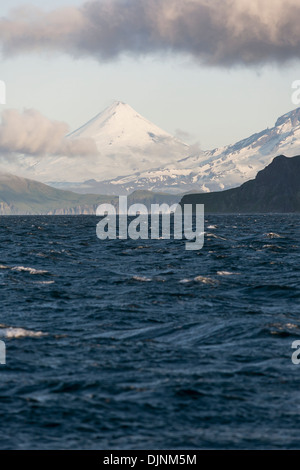 Shishaldin Volcano, The Flank Of Isanotski Peaks And The Rugged Cliff Shoreline Of Cape Pankof On Unimak Island Stock Photo