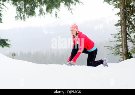 Apr. 01, 2010 - Spokane, Washington, USA - Linda Lilard is an elite runner with the running club Team Swift based out of Spokane, Washington. She runs at Mt. Spokane Ski Resort on a snowy spring day dressed in winter running gear and running through evergreen trees, snow, trails on a cloudy winter like day. (Credit Image: © Jed Conklin/ZUMApress.com) Stock Photo