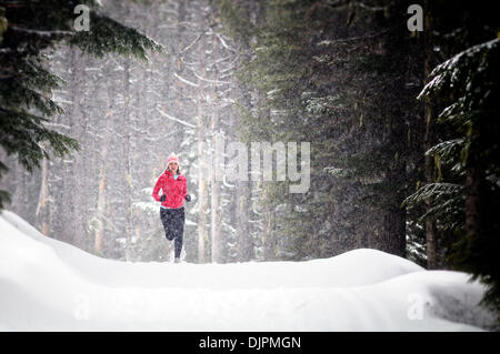 Apr. 01, 2010 - Spokane, Washington, USA - Linda Lilard is an elite runner with the running club Team Swift based out of Spokane, Washington. She runs at Mt. Spokane Ski Resort on a snowy spring day dressed in winter running gear and running through evergreen trees, snow, trails on a cloudy winter like day. (Credit Image: © Jed Conklin/ZUMApress.com) Stock Photo
