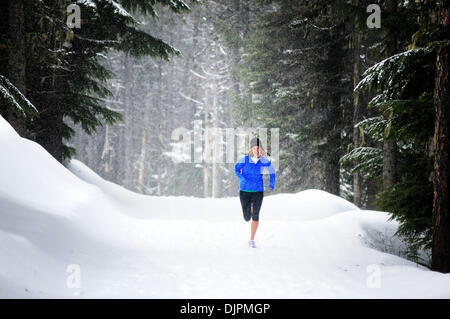 Apr. 01, 2010 - Spokane, Washington, USA - Sara Ranson is an elite runner with the running club Team Swift based out of Spokane, Washington. She runs at Mt. Spokane Ski Resort on a snowy spring day dressed in winter running gear and running through evergreen trees, snow, trails on a cloudy winter like day. (Credit Image: © Jed Conklin/ZUMApress.com) Stock Photo