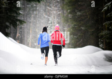 Apr. 01, 2010 - Spokane, Washington, USA - Linda Lilard and Sara Ranson are elite runners with the running club Team Swift based out of Spokane, Washington. They run at Mt. Spokane Ski Resort on a snowy spring day dressed in winter running gear and running through evergreen trees, snow, trails on a cloudy winter like day. (Credit Image: © Jed Conklin/ZUMApress.com) Stock Photo