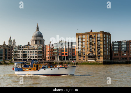 Boat on River Thames passing St Paul's Cathedral Stock Photo