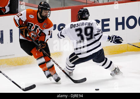 Mar. 27, 2010 - Albany, New York, U.S - 27 March 2010: RIT Forward Stevan Matic (12) fights for the puck with New Hampshire Forward  Paul Thompson  (17) and Forward  Phil DeSimone (39)  during ice hockey action between New Hampshire and Rochester Institute of Technology (RIT) at the East Regional Tournament final of the 2010 NCAA Hockey Championship held at Times Union Center in Al Stock Photo