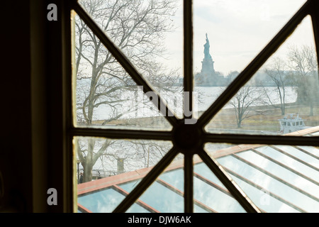 Statue of Liberty framed by Ellis Island hall window, in New York, US Stock Photo