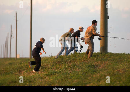 Oct. 23, 2010 - West Palm Beach, FL - Florida, USA - United States - (transmit)  fl-alligator-hunt-1023b  --   Hunters sneak up on a resting alligator on the banks of the Stormwater Treatment Area 1-West while trying to  hook a gator for Greg Amira, left, during the Wounded Warrior Project alligator hunt, Saturday night, October 23, 2010.  Michael Laughlin, Sun Sentinel (Credit Ima Stock Photo