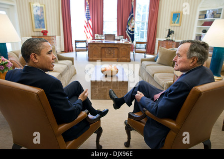 US President Barack Obama meets with former President George H.W. Bush in the Oval Office of the White House February 15, 2011 in Washington, DC. Stock Photo
