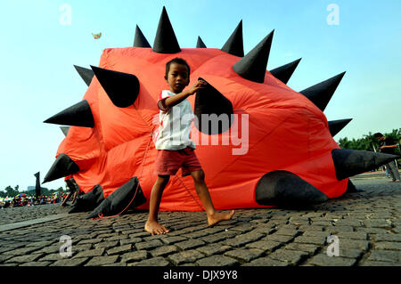 Jakarta, Indonesia. 1st Dec, 2013. A boy walks past a kite during the Jakarta International Kite Festival 2013 in Jakarta, Indonesia, Nov. 30, 2013. The two-day festival opened on Saturday, with the participation of 18 countries and regions. Credit:  Agung Kuncahya B./Xinhua/Alamy Live News Stock Photo