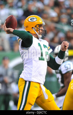 A Green Bay Packers fan wearing a cheesehead and a Aaron Rodgers #12 jersey  and a Denver Broncos fan wearing Peyton Manning's #18 jersey watch as  Packers QB Aaron Rodgers enters the