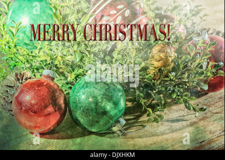Merry Christmas vintage ornaments still life boxwood branch wood table textured faded nostalgic feel. Blank version see DJXHRT Stock Photo