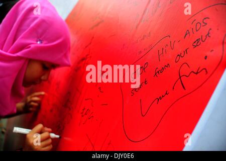 Jakarta, Indonesia. 1st Dec, 2013. An Indonesian student signs on a board during an HIV/AIDS awareness campaign on the World AIDS Day in Jakarta, Indonesia, Dec. 1, 2013. Credit:  Zulkarnain/Xinhua/Alamy Live News Stock Photo