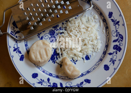 Sheep's cheese grated coarsely by a hand-held grater. Stock Photo