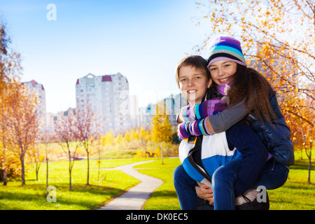 10 and 11 years old couple of school kids, boy an girl in warm autumn clothes Stock Photo