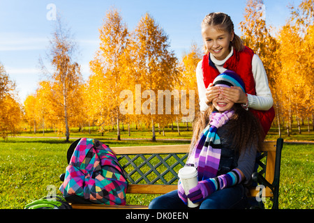 Two happy school age kids playing guessing who am I covering eyes with palms Stock Photo