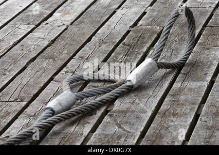 Mooring equipment on wooden pier. Steel rope Stock Photo