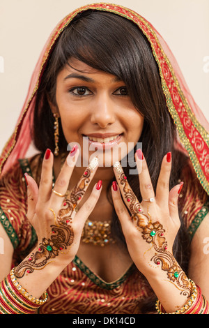 Portrait of an Indian woman dressed in traditional sāri and sporting henna tattoos on her hands. Stock Photo