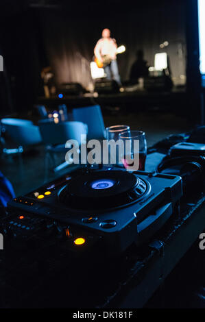 A musician plays on stage with a sound mixing desk in the foreground Stock Photo