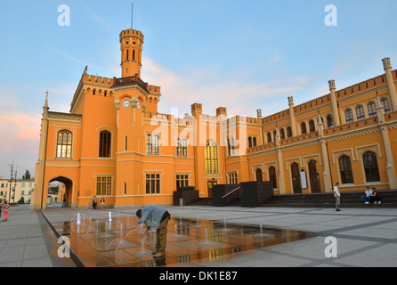 Man drinking from fountain in front of the Main Railway Station, Wroclaw, Poland Stock Photo