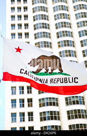 Low angle view of California state flag flying in front of highrise building, California, United States