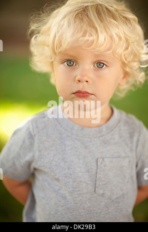 Portrait Of Blonde Toddler Boy With Curly Hair Holding Yellow Ball