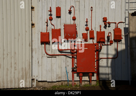 Old red electric junction boxes and lamps labeled electrical supply disconnected. Stock Photo