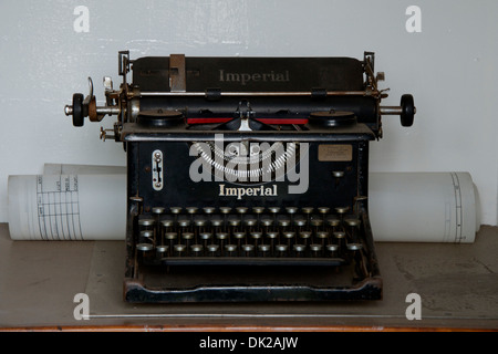 Pre-war Vintage Imperial 50 typewriter on a desk with a roll of architectural paper. Stock Photo