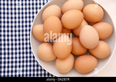 View from directly above of organic brown eggs on checkered gingham napkin from directly above Stock Photo